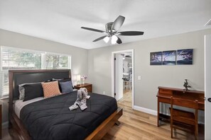 A bedroom with a bed, bedside table, lamp, and artwork. - Beautiful 4/2 house, minutes from Busch Gardens (Tampa)