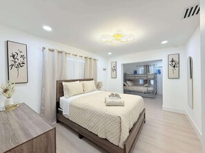 Ein Schlafzimmer mit einem Bett, einem Nachttisch und Blick ins Bad.