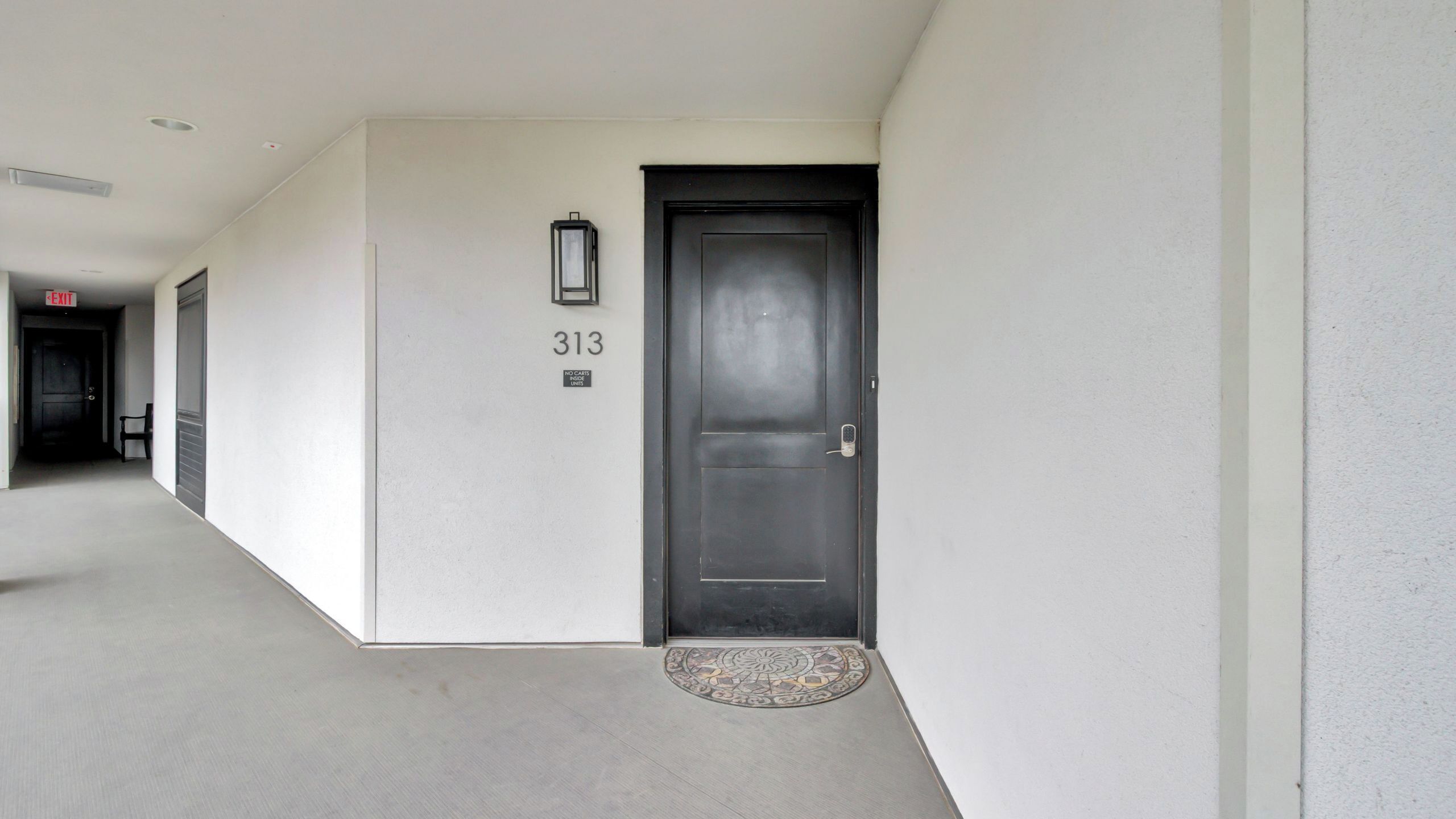 A hallway with a black door marked '313' and a 'NO CAR' sign.