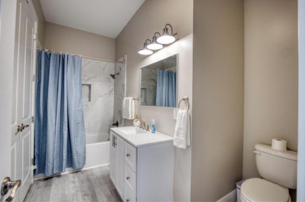 Une salle de bain équipée d’une douche, d’un lavabo, d’un miroir et de toilettes.