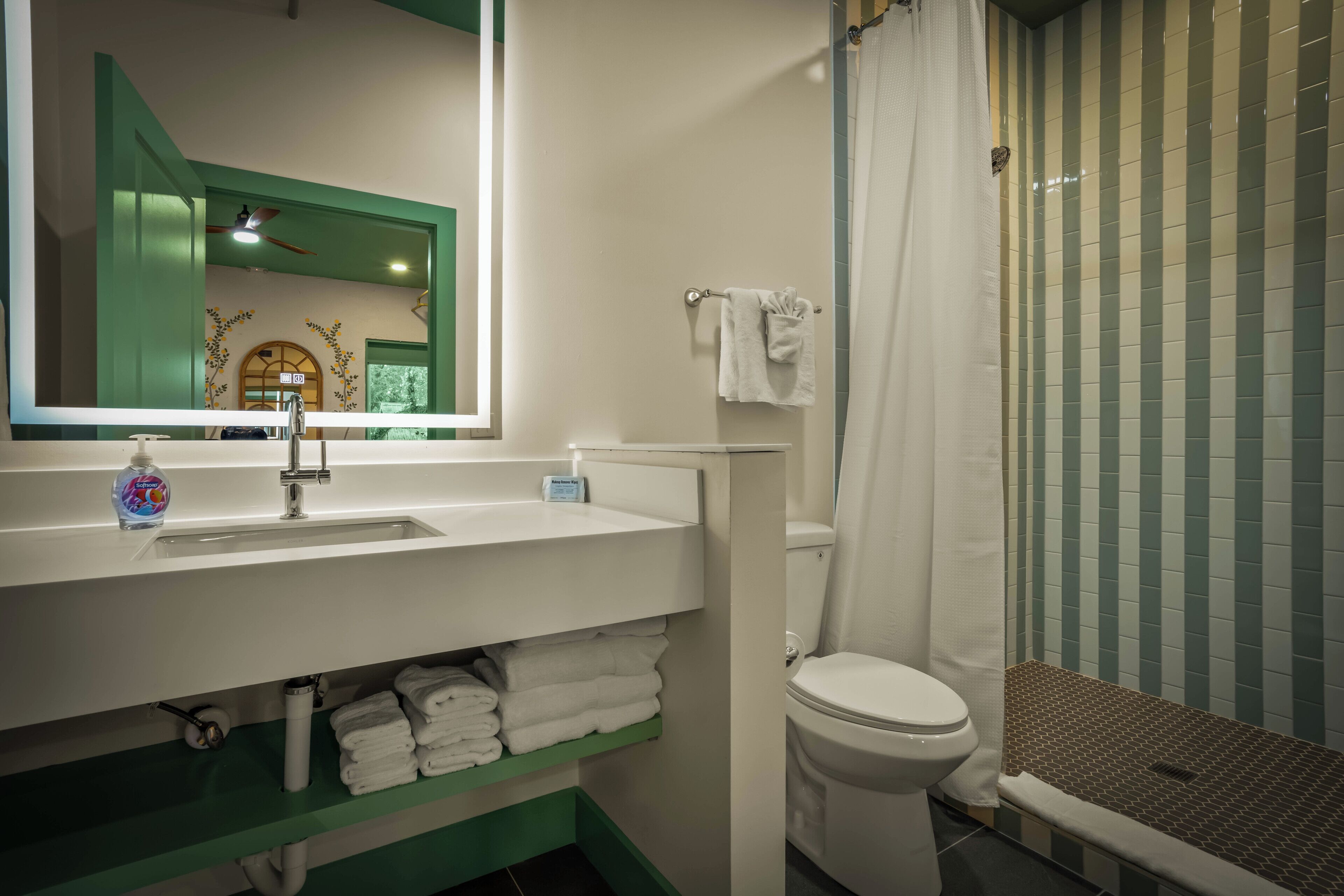A bathroom with a sink, toilet, and shower.