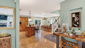 Une cuisine spacieuse dotée de meubles en bois, d’un îlot central et d’un coin repas avec des chaises.