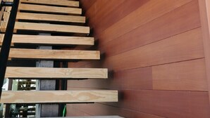 En trappe i træ med et moderne design, der fører op til en etage.