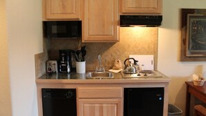 A compact kitchen with wooden cabinets, a microwave, a coffee maker, a kettle, and a dishwasher. - Resort studio condo 1/2 mile from Main Street in Breckenridge (Breckenridge)