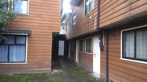 A narrow alleyway between two wooden buildings with a door and windows. - B3 Furnished cabin near downtown Puerto Montt (Puerto Montt)