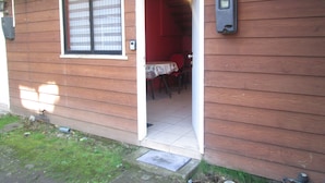 A wooden house with a door leading to an interior space containing a table and chairs. - B3 Furnished cabin near downtown Puerto Montt (Puerto Montt)