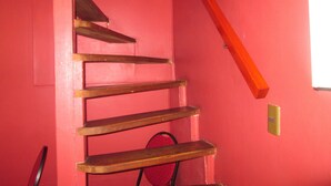 A staircase with wooden steps against a red wall. - B3 Furnished cabin near downtown Puerto Montt (Puerto Montt)