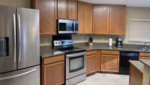 A kitchen with stainless steel appliances, wooden cabinets, and a granite countertop. - Sleeps 20 w/Pool Near SeaWorld/6-flags & AFB (San Antonio)