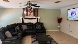 A living room with a sectional sofa, a coffee table, a ceiling fan, a fireplace, and a flat-screen TV. - Sleeps 20 w/Pool Near SeaWorld/6-flags & AFB (San Antonio)