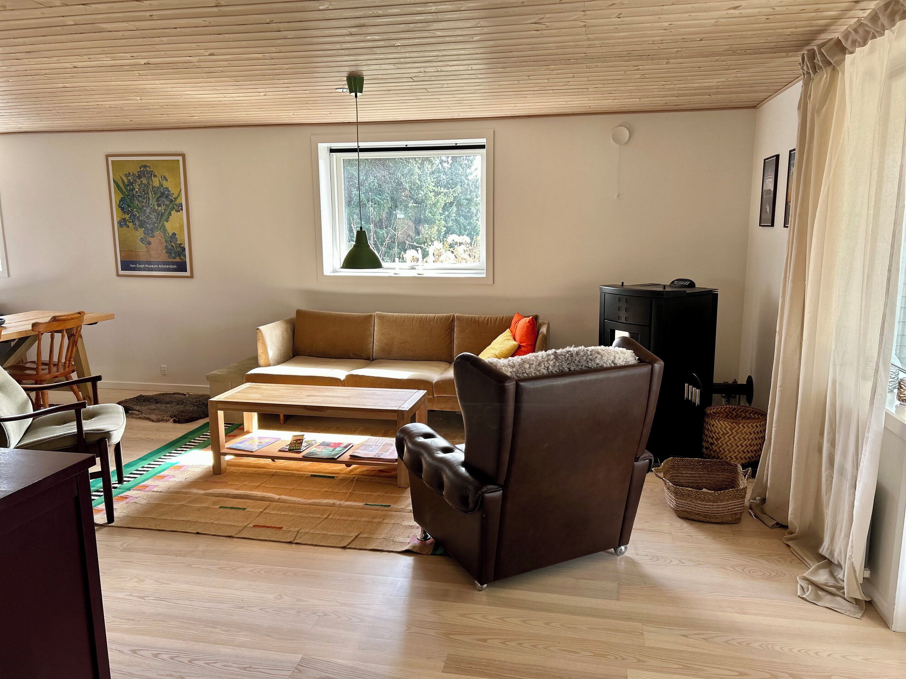 Un salon comprenant un canapé, un fauteuil, une table basse et un plafond en bois.