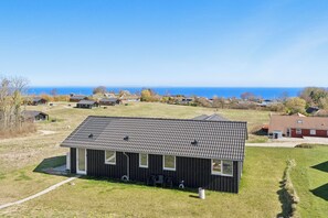 A modern house with a flat roof, large windows, and a view of the sea. - New 2026 holiday home with spa near beach (Augustenborg)