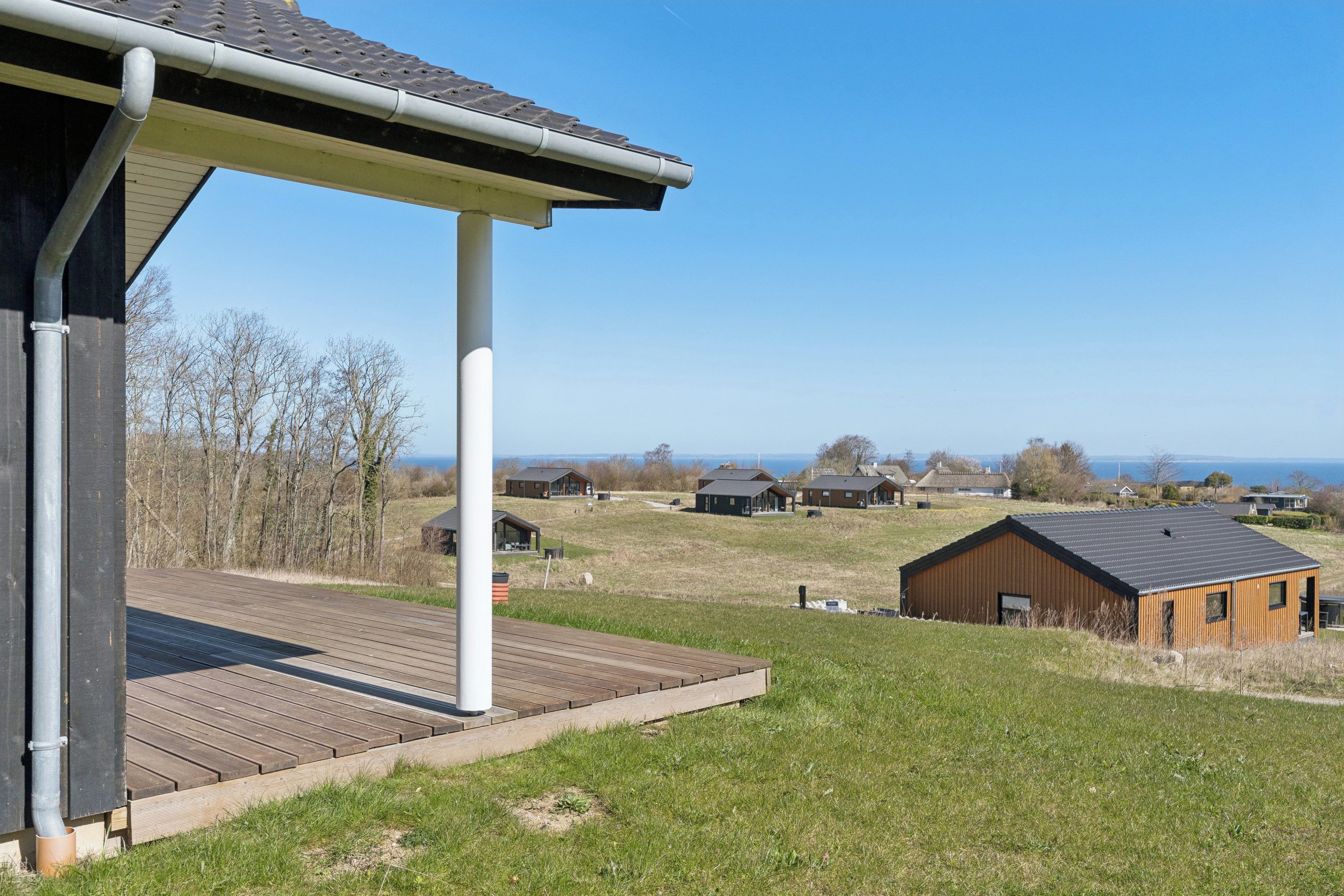 A residential area with houses, a wooden deck, and a clear sky.