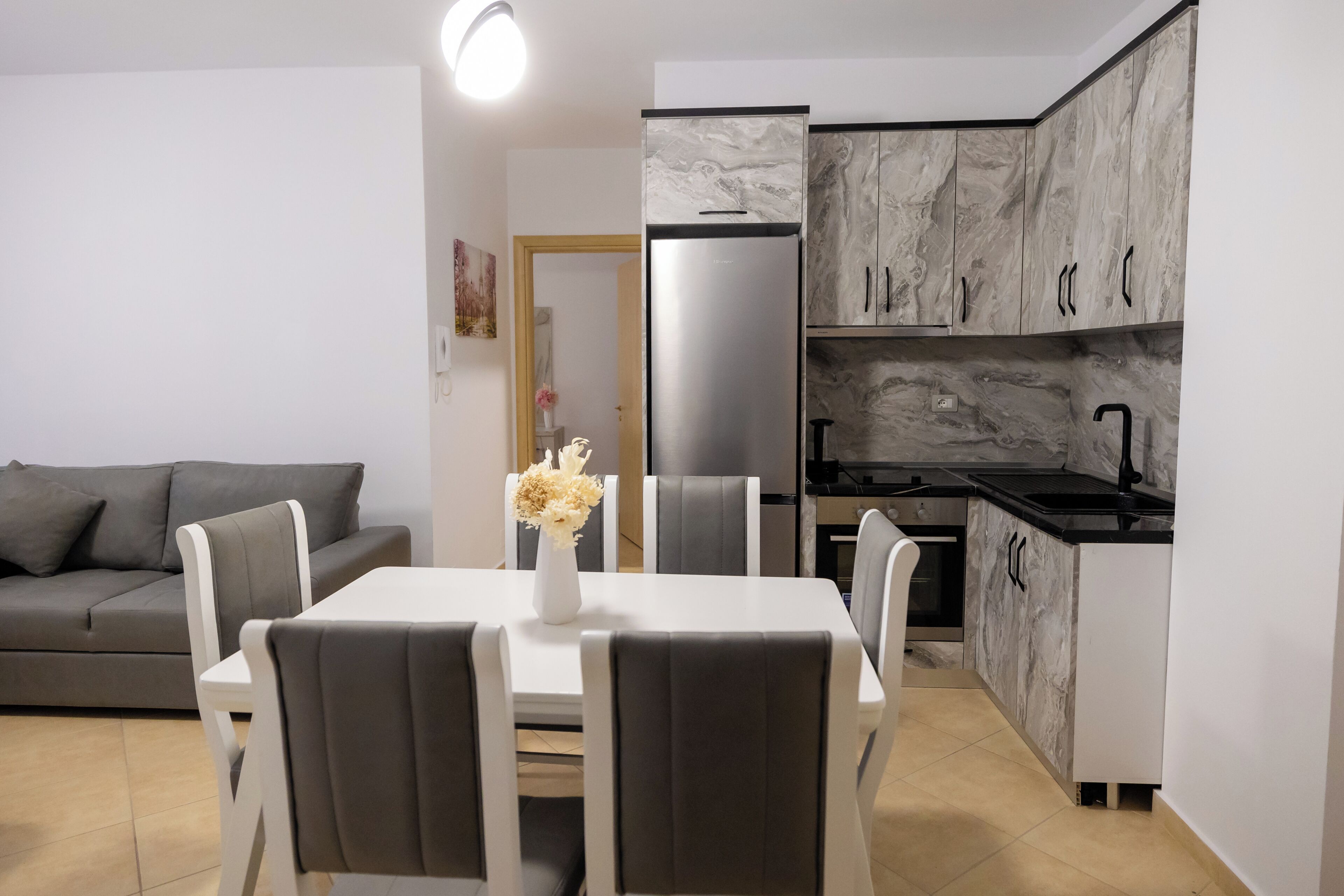 A compact kitchen with a refrigerator, stove, and marble cabinets.