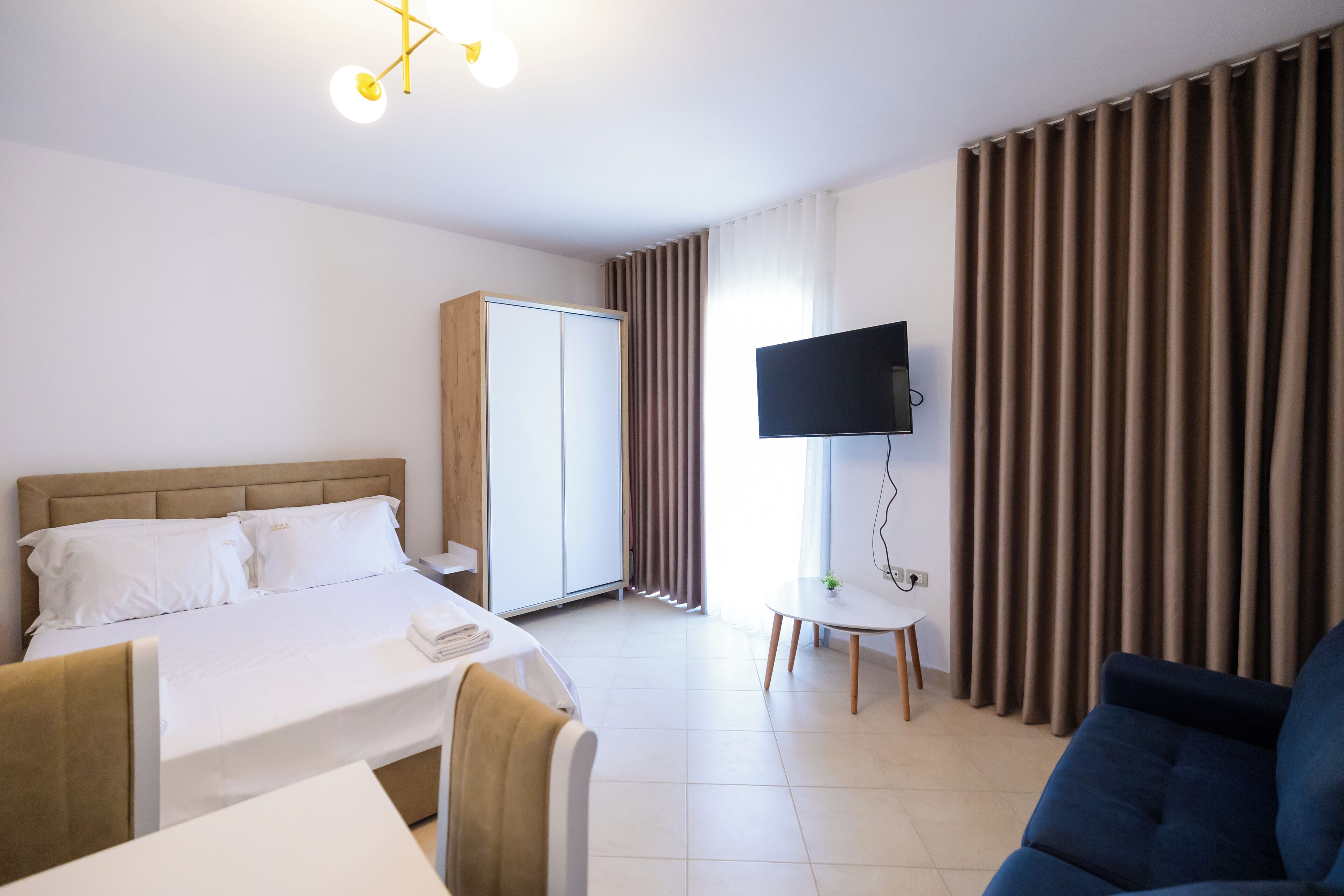 Een hotelkamer met een bed, een televisie, een bureau en een stoel.