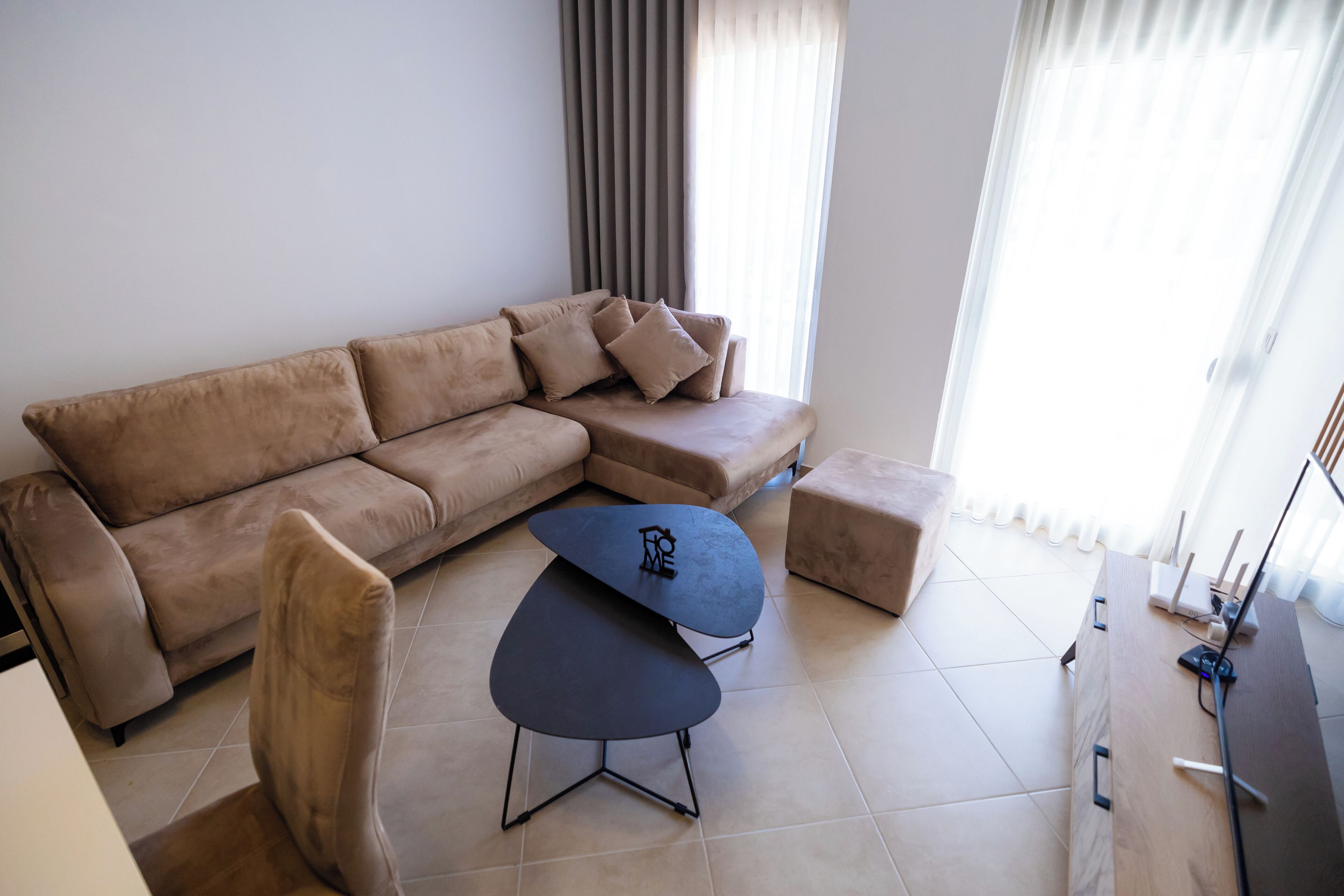 Una sala moderna con un sofá modular, una mesita de centro y un sillón.