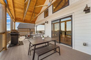 Eine Terrassenausstattung mit Grill, Tischen und Stühlen.