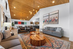 A spacious living area with a wooden ceiling, two sofas, a coffee table, and a patterned rug. - Lake View~Hot Tub, Arcade, Pool, 1mi to SilverDC (Branson)