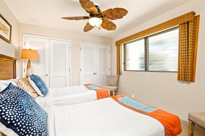 A hotel room with two beds, a ceiling fan, a window with curtains, and a chair. - Valley Isle Villas | Oceanfront 2 BR | Car Incl. w/ 6+ Nights | VIR-508 by KBM (Lahaina)