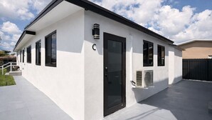 Un bâtiment moderne doté d’un toit plat, de grandes fenêtres et d’une porte avec un panneau de verre.