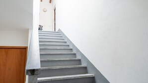 Eine Treppe mit einer Holztür unten und einer weißen Wand darüber.
