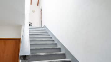 Eine Treppe mit einer Holztür unten und einer weißen Wand darüber.