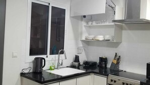 A modern kitchen with a stove, oven, and a window. - Escape to Eden heights,a 2 bedroom Apt with Gym access near the West Hills Mall. (Weija, Accra)