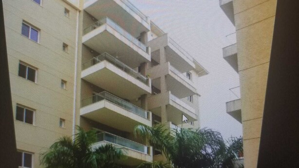 A multi-story building with balconies, a flat roof, and surrounding greenery. - Escape to Eden heights,a 2 bedroom Apt with Gym access near the West Hills Mall. (Weija, Accra)