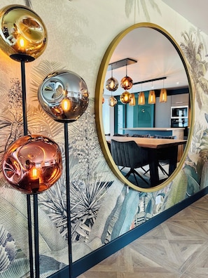A modern interior with a dining area, a kitchen, and a large mirror reflecting the space. - La Bastide du Causse - Domaine Gouloumès (Ginouillac)