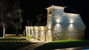 A stone building with a pool in front, illuminated at night. - La Bastide du Causse - Domaine Gouloumès (Ginouillac)