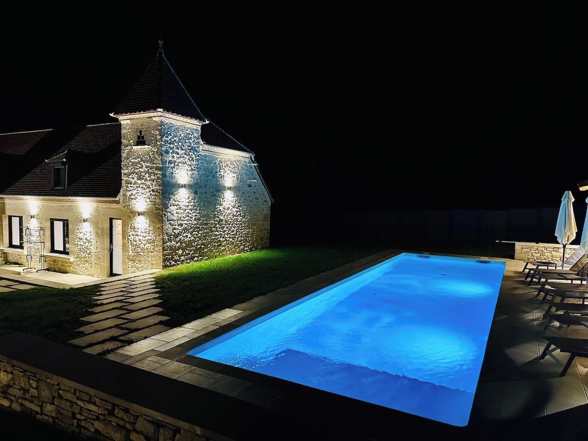 Un edificio de piedra con piscina por la noche.