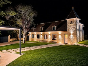 A stone building with a tower, a paved driveway, and a well-maintained lawn. - La Bastide du Causse - Domaine Gouloumès (Ginouillac)