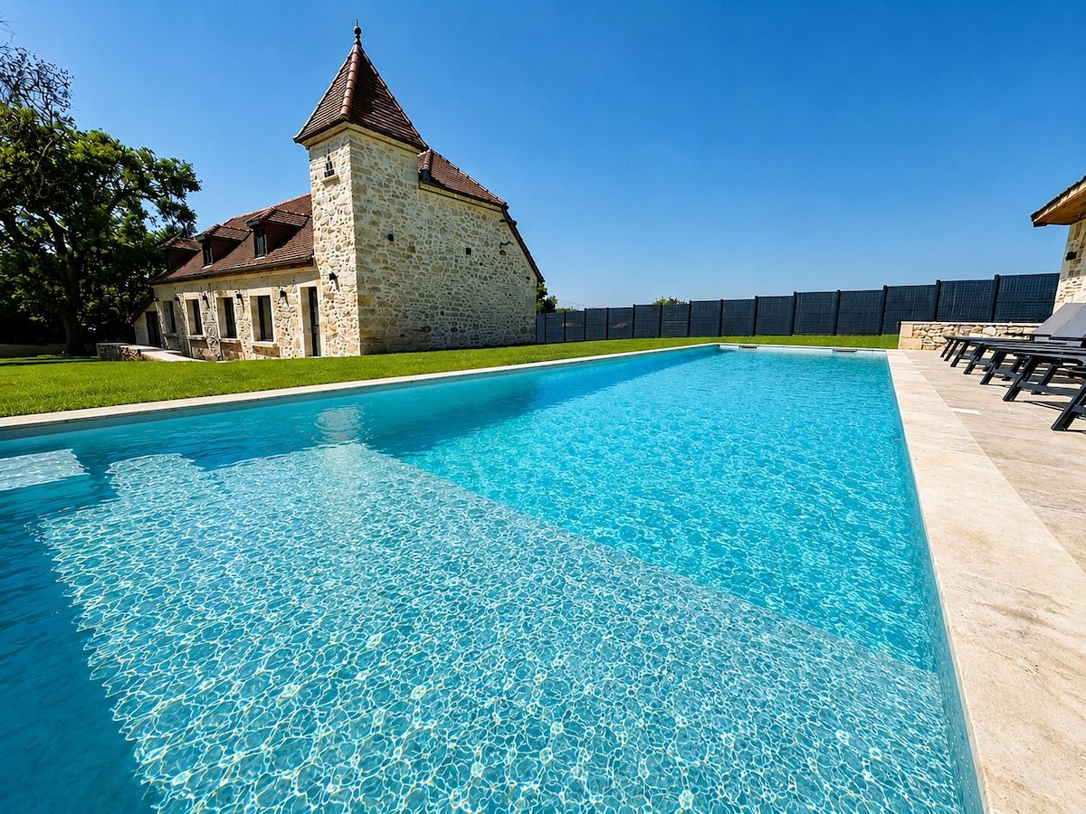 A swimming pool with a stone building in the background.