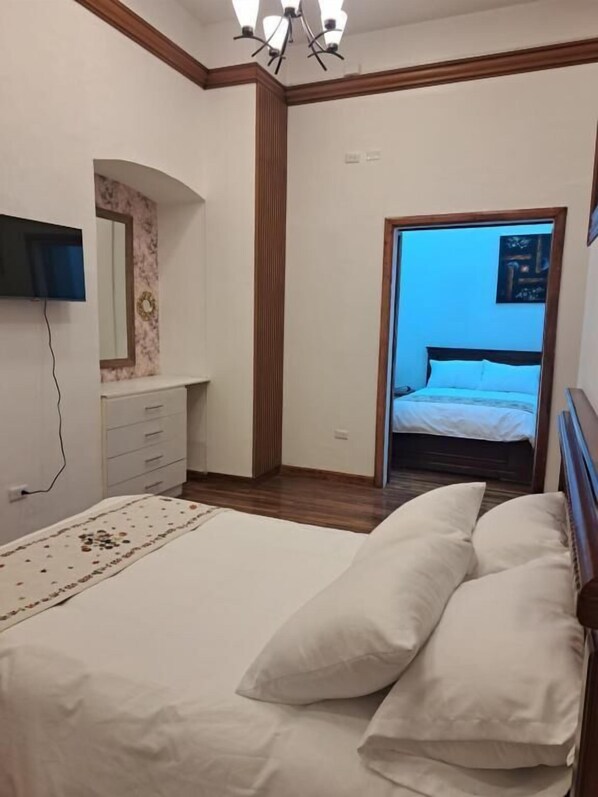A bedroom with a bed, a dresser, a mirror, and a television. - Rossa Mia Hotel Boutique (Quito)