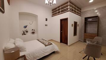 Un dormitorio moderno con cama, una silla, un escritorio, una araña y un armario.