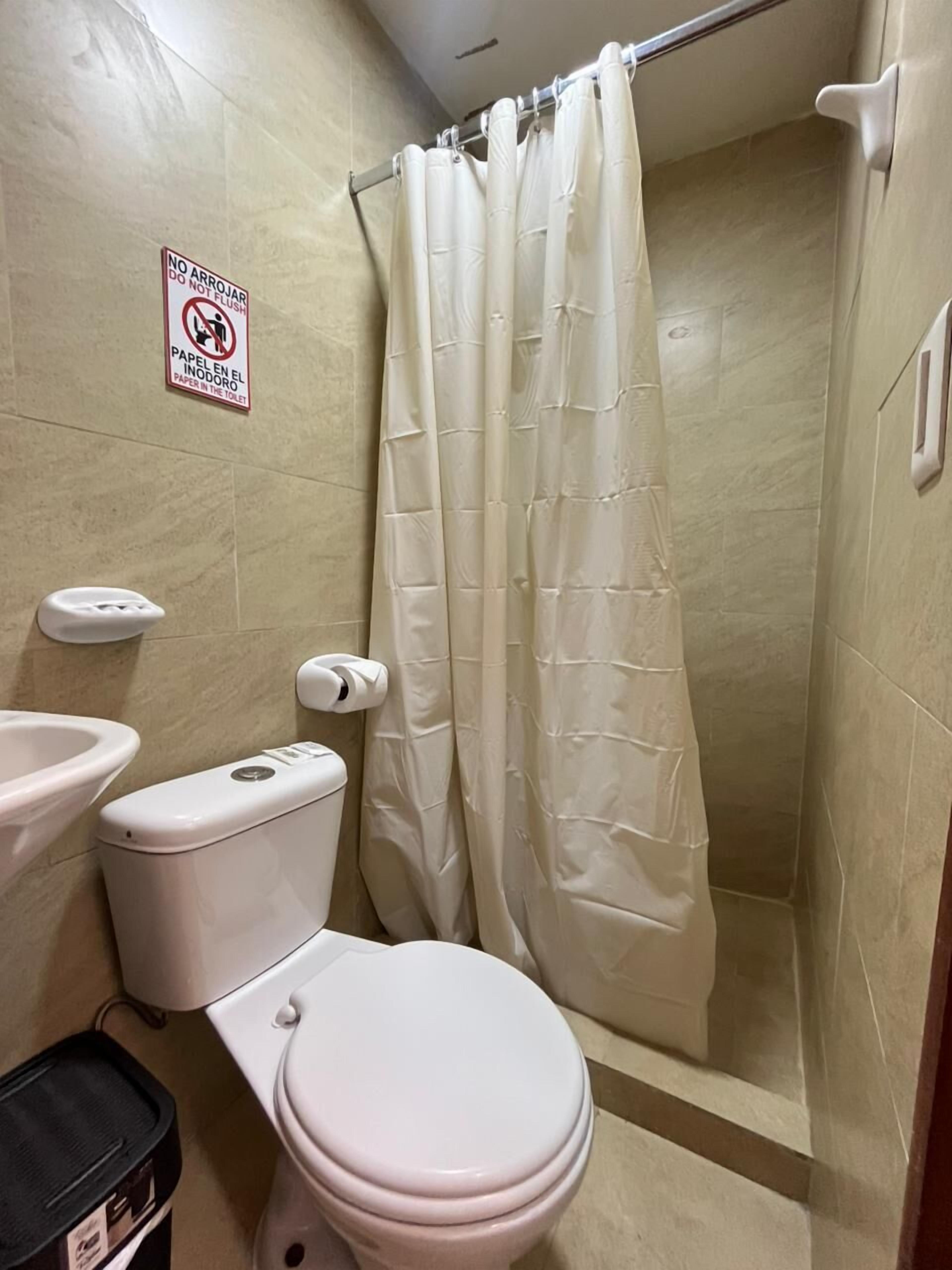 Un baño con inodoro, bidé y cortina de ducha.