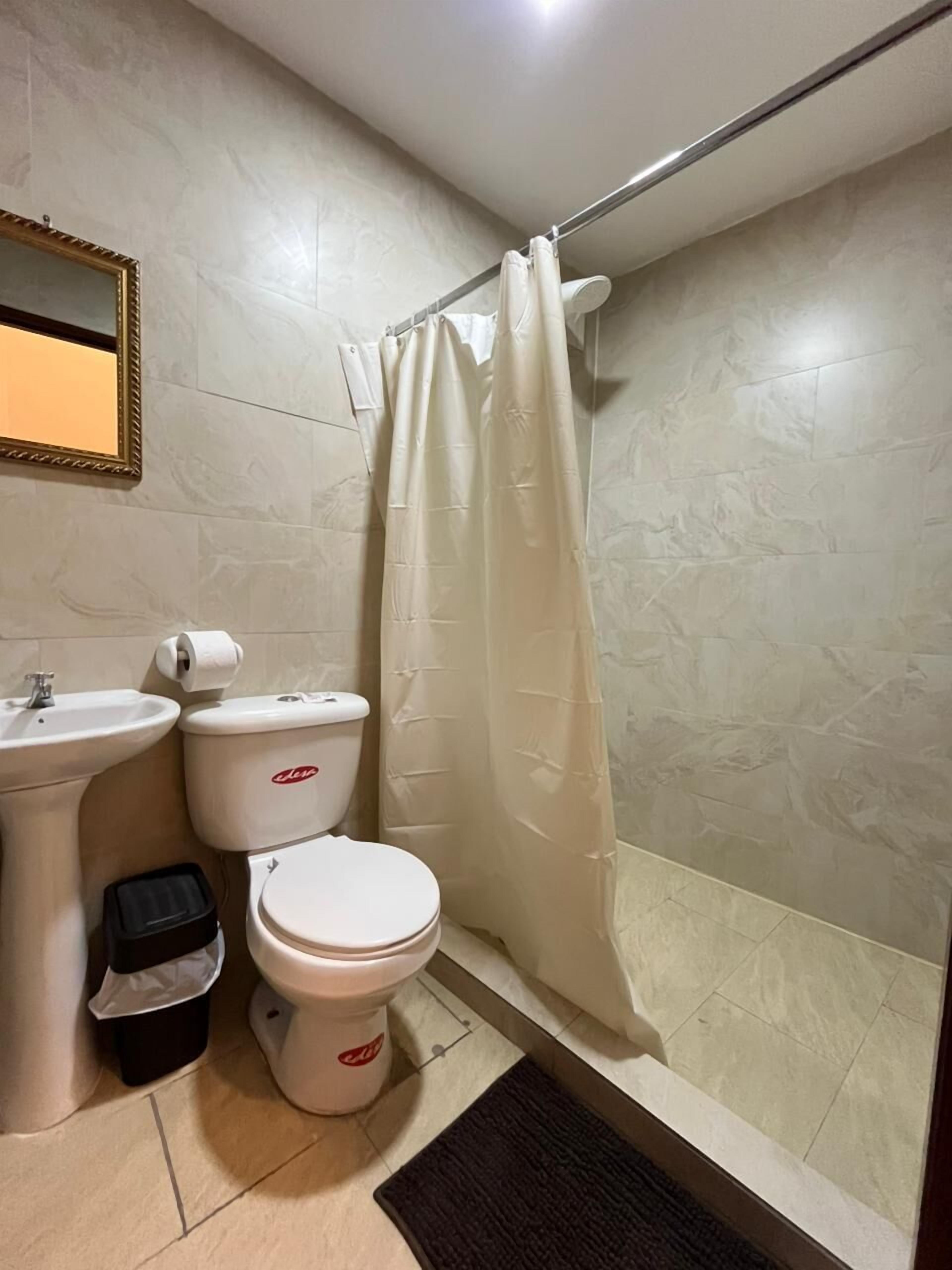 A bathroom with a toilet, bidet, and sink.