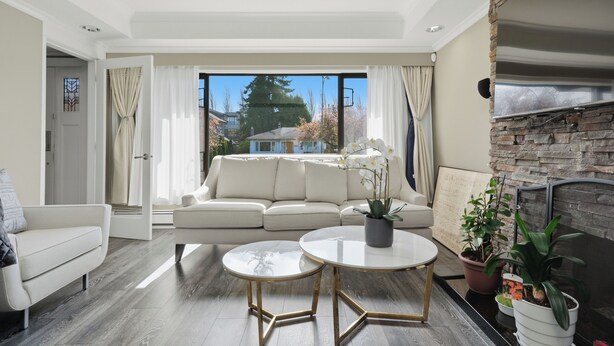 A modern living room with a sofa, two coffee tables, and a fireplace. - Luxury 5BR Point Grey | Jericho Beach + Downtown (Vancouver)