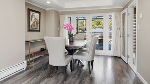 A dining area with a table, chairs, and a potted plant. - Luxury 5BR Point Grey | Jericho Beach + Downtown (Vancouver)
