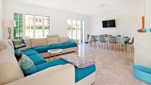 Un salon comprenant un canapé, une table basse et un coin repas avec des chaises et une table.