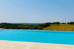 A swimming pool with a view of a green landscape and hills in the distance. - Le Belvédère du Quercy - Domaine Gouloumès (Soucirac)