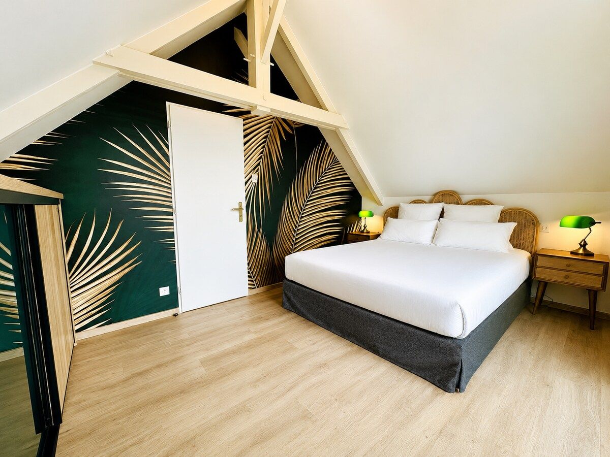 Une chambre à coucher avec un lit, des tables de chevet et une porte.