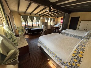 Een kamer met een bed, een bureau, een stoel en een raam.