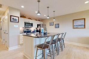 A modern kitchen with a central island, stainless steel appliances, and pendant lighting. - LPC4A Shared Pool, Charcoal Grill, Garage Access, Boat Parking (Port Aransas)