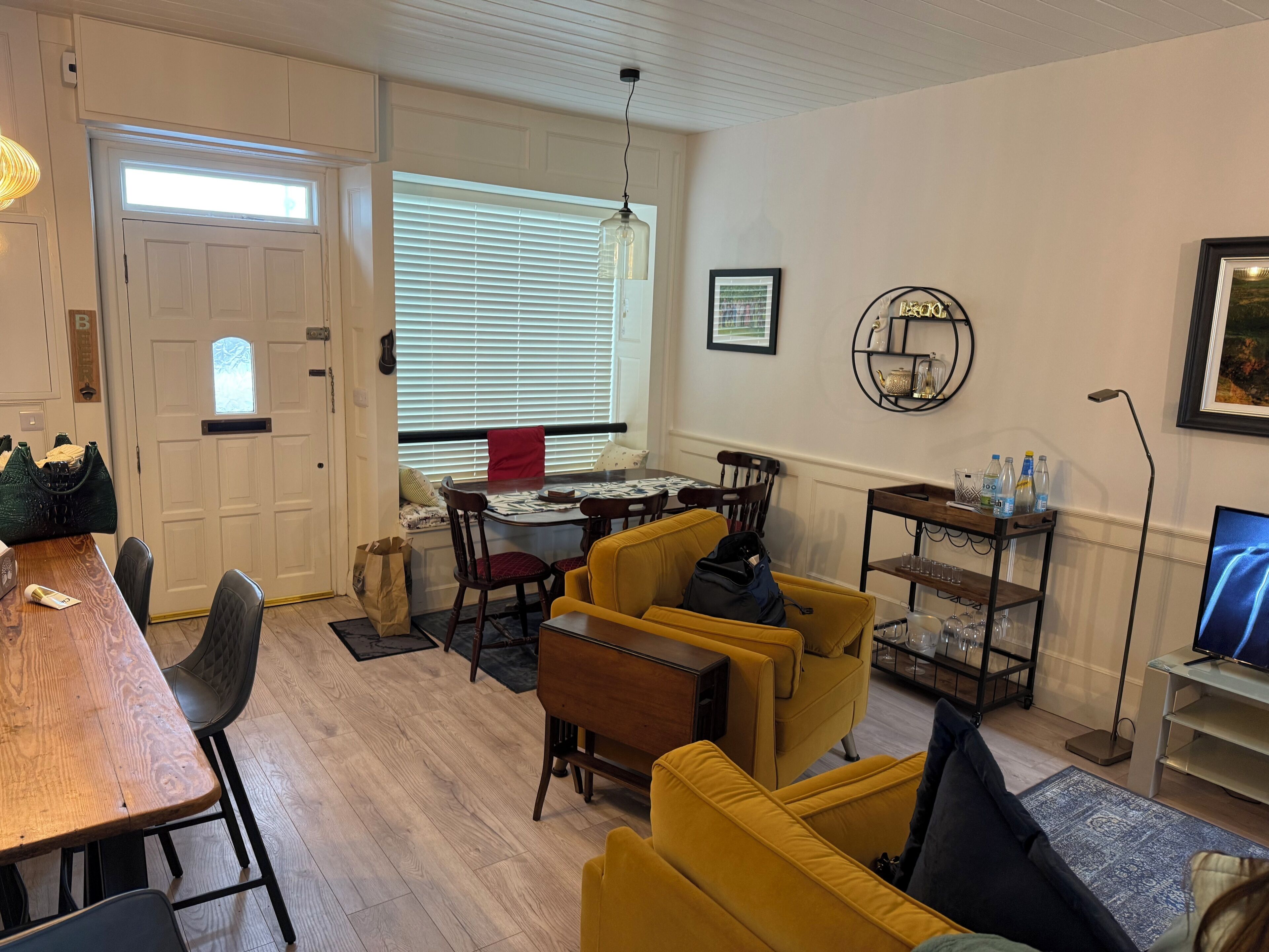 Un área de comedor con una mesa, sillas, un sofá, una mesa de centro y un televisor.