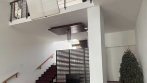 Eine Treppe führt zu einer Zwischenebene, auf der sich ein Fernseher befindet.