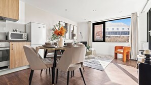 Eine moderne Küche mit Mikrowelle, Backofen und Essbereich mit Stühlen und Tisch.