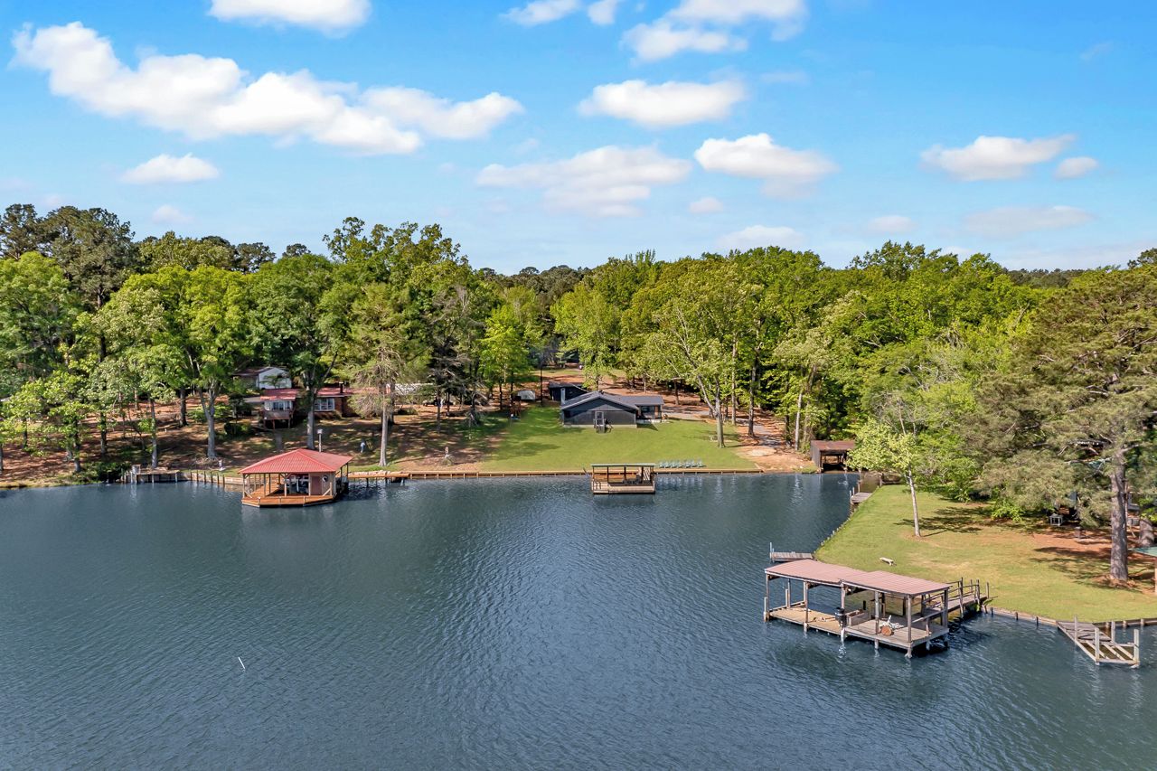 A lakeside property with docked boats, a gazebo, and a cabin.