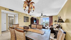 A dining area with a glass table, woven chairs, a ceiling fan, and a view of the outside. - 🦩Book Me Baby! Pinkie's Island Oasis🦩 (Destin)