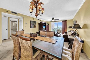 A dining area with a glass table, woven chairs, a ceiling fan, and a view of the outside. - 🦩Book Me Baby! Pinkie's Island Oasis🦩 (Destin)