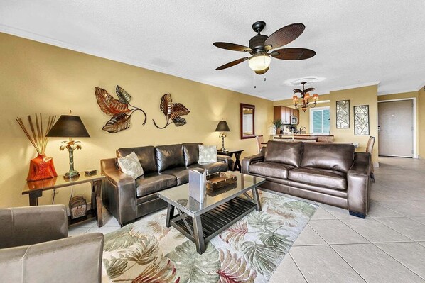 A living room with a sofa, coffee table, and decorative wall art. - 🦩Book Me Baby! Pinkie's Island Oasis🦩 (Destin)